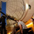 A person with a telescope stargazing at a Carter Observatory dome.