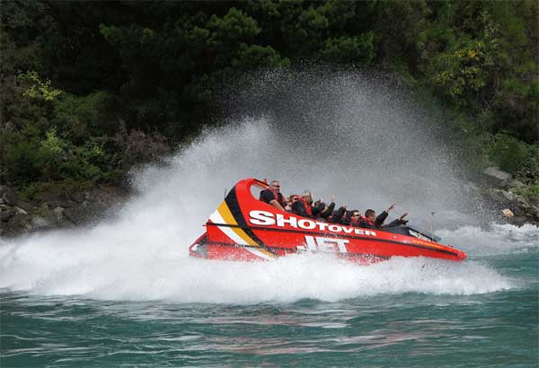 Jetboat in the shotover river with a big spray of water