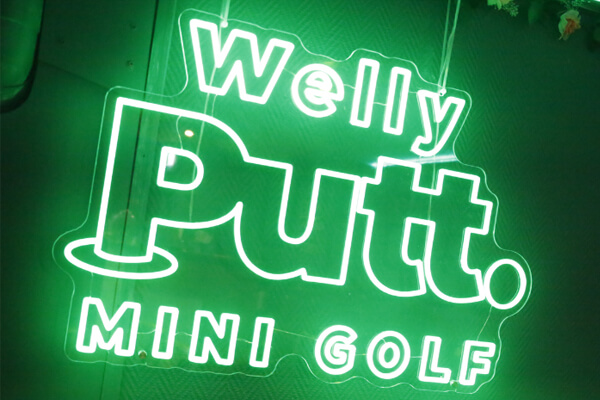 Bright neon sign of Welly Putt. 
